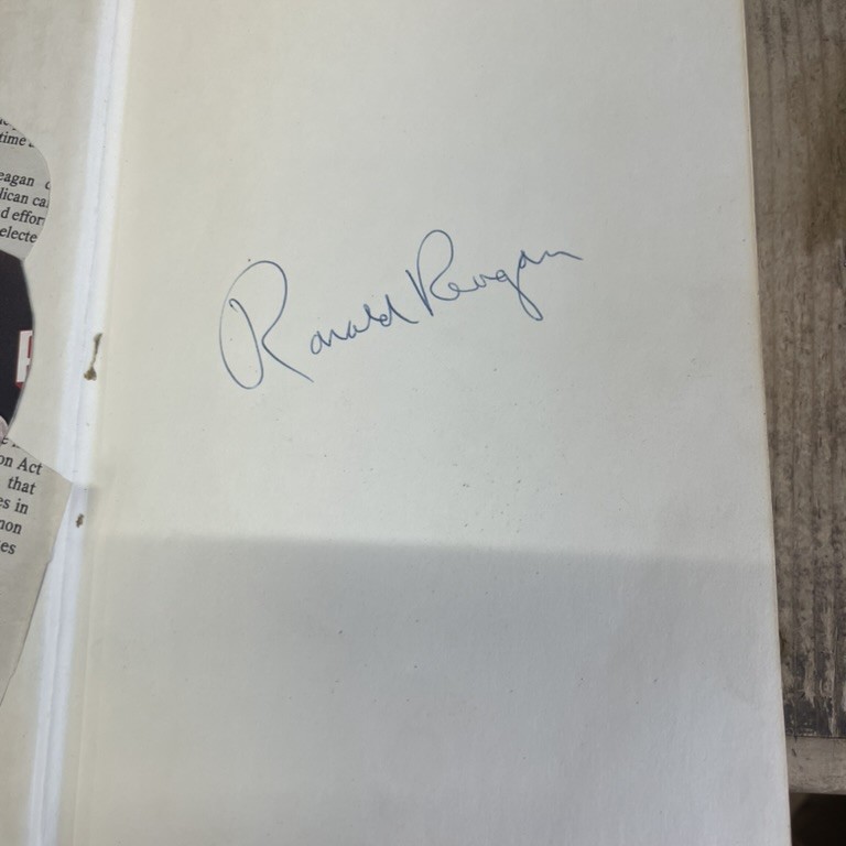 Handwritten 'Ronald Reagan' signature in blue ballpoint pen on the front endpaper.